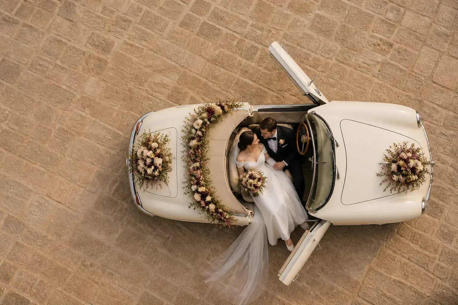 Novios en un coche clásico decorado con flores